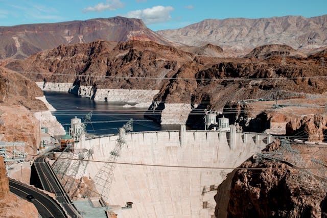 Aerial view of Hoover Dam and the Colorado River with low water levels, symbolizing drought and declining reservoirs.