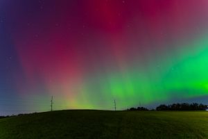 Aurora borealis shining above rural Pennsylvania fields, illustrating the impact of space weather on Earth’s atmosphere.